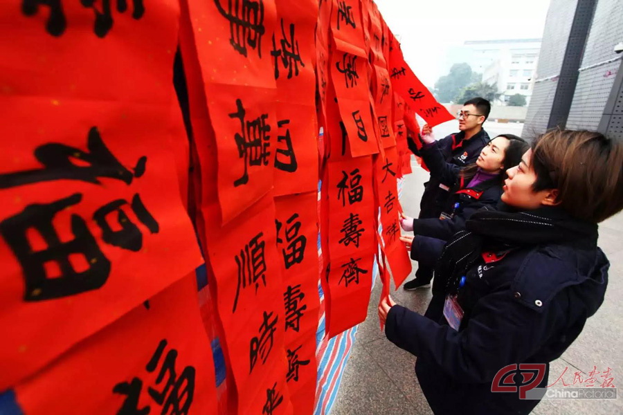 周闽-为职工写书法送祝福（航空工业成飞文联书画协会会员坚持11年义务为员工写赠春联。）.jpg