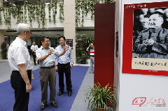 _人民画报执行总编王继雨（中）向上海图书馆馆长吴建中（左）、上海科技文献出版社社长梅雪林（右）介绍展览情况。