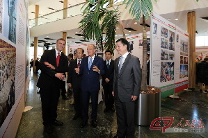 中国外文局局长周伟明（右一）向匈牙利前总理麦杰希（中）等来宾介绍《美丽中国 美丽匈牙利》图片展
