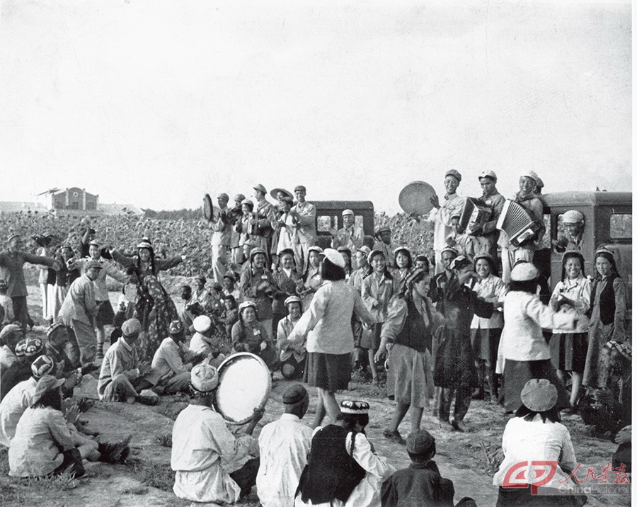 胜利农业生产社的社员们，参观某农场拖拉机耕作，并高兴和战士们联欢。（1955年）.jpg