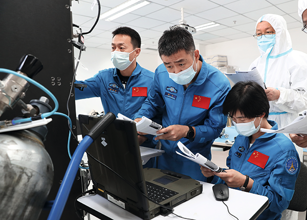 P09--神舟十四号航天员乘组在科学实验机柜操作中.png