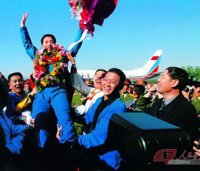 2003年10月16日 执行神舟五号任务航天员杨利伟返回西郊机场被欢呼的人群抛起 摄影：朱九通-f.jpg