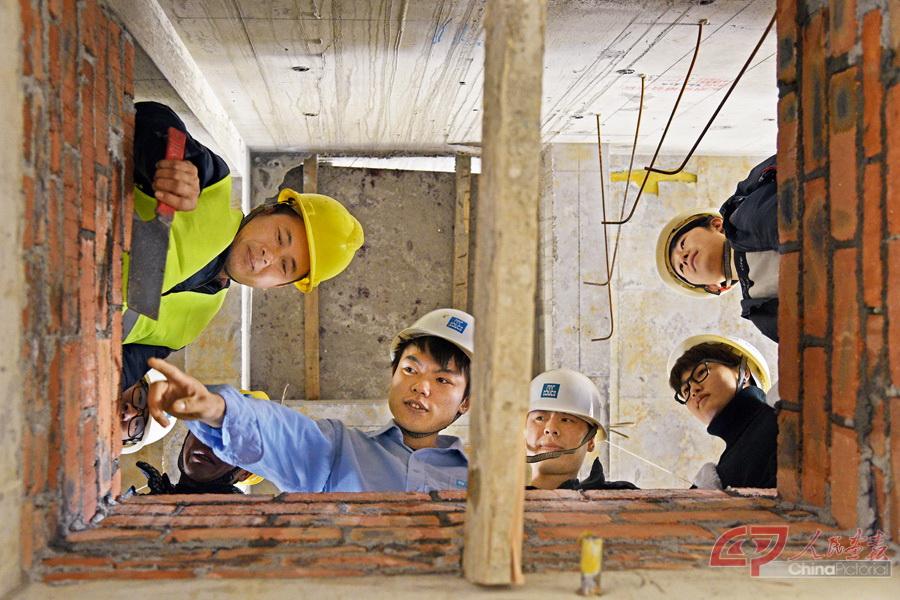 2018年2月8日，全国人大代表、中建五局总承包公司项目质量管理员正在与工友切磋砌筑质量，摄影记者湘声报闫利鹏.jpg