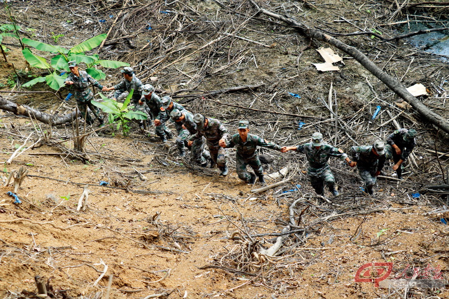 南部战区陆军云南扫雷大队四队组织M04004号雷场验收移交时，官兵们手拉着手徒步验收雷场。中间就是杜富国。（杨萌 摄）.jpg