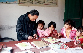 李祖清在办公室里帮孩子们削铅笔。平时，他不仅要帮孩子们检查作业，像削笔这样的细琐小事也一定亲力亲为。