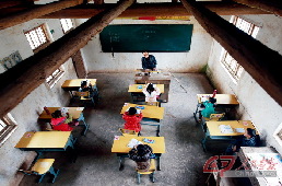 李祖清在给学前班的7名孩子上语文课。教室是一间砖瓦房。一张很“古老”的木桌与孩子们崭新的课桌相对，那便是讲台。李祖清的竹杖就立在讲台边。