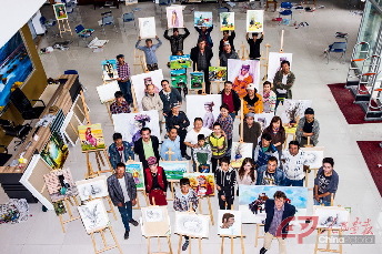 图书馆大厅，“新疆油画学会油画艺术辅导班”师生们与他们的作品合影留念。