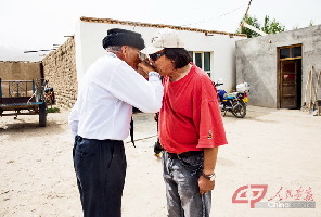 提孜那甫村，前去拜访的画家王光新（右）与巴依卡互敬吻手礼。