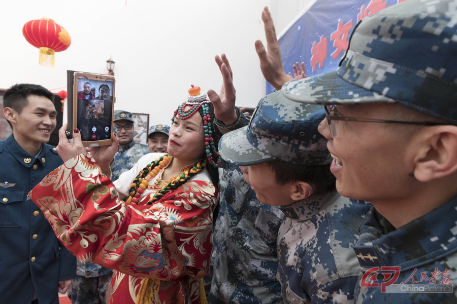 37 在婚礼现场，官兵们特意设置了“视频连线”环节，让新人双方的亲人都能通过视频观看婚礼的准备过程和婚礼现场盛况。新人的父母通过手机观看婚礼实况，）.jpg