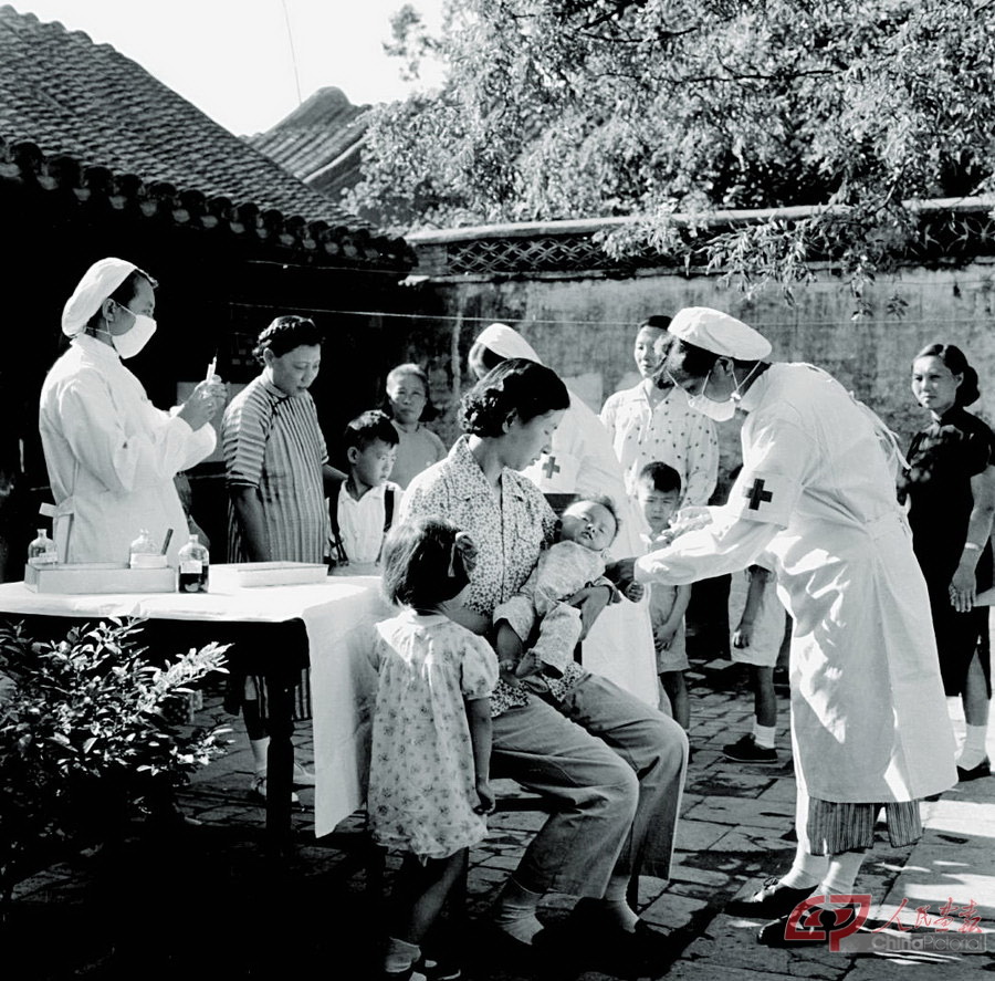 02-1957年，在北京香家园武衣库胡同，卫生站的卫生员为居民的孩子注射大脑炎预防针。.jpg