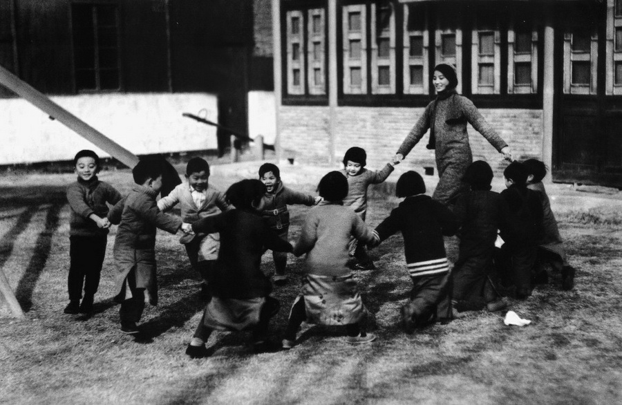 5.1935年12月30日，南京金陵女子文理学院的一位年轻的幼教老师带着孩子们在草坪上做游戏。秦风供图（原载《老照片》第6辑）.jpg