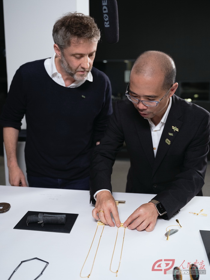 7、展览特约赞助商周大福珠宝集团首席品牌官陈义邦（右一）向参展艺术家安迪·古特(Andi Gut)介绍周大福珠宝为本次展览设计的周大福传喜系列特别版.JPG