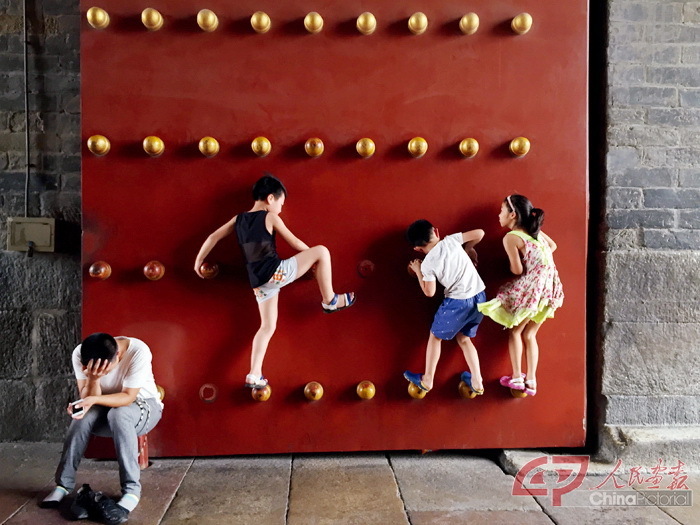 2015年8月17日，北京，三名顽皮的孩童在正阳门玩耍。 摄影 冯中豪