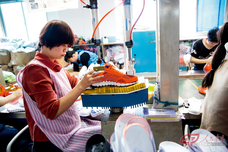 福建泉州匹克集团运动鞋生产车间,工人在制鞋流水线上工作.
