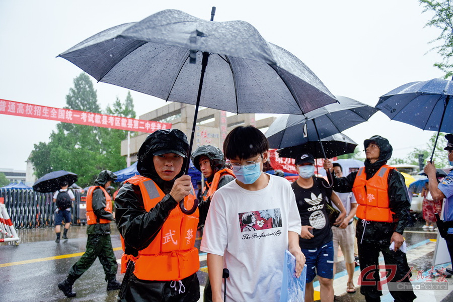 1 7月8日中午，歙县高考生第一场考试结束，武警黄山支队官兵为考生撑伞送他们上接驳大巴.jpg