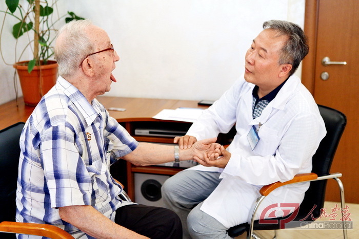 黑龙江中医药大学附属第二医院的唐强教授为参加过解放中国东北战斗的二战老兵弗拉基米尔检查身体。