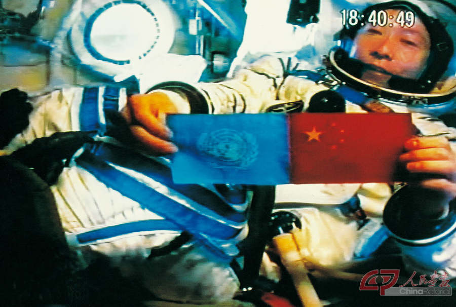 203年10月15日18时35分，杨利伟在太空展示联合国国旗和中华人民共和国国旗。  秦宪安 摄.jpg