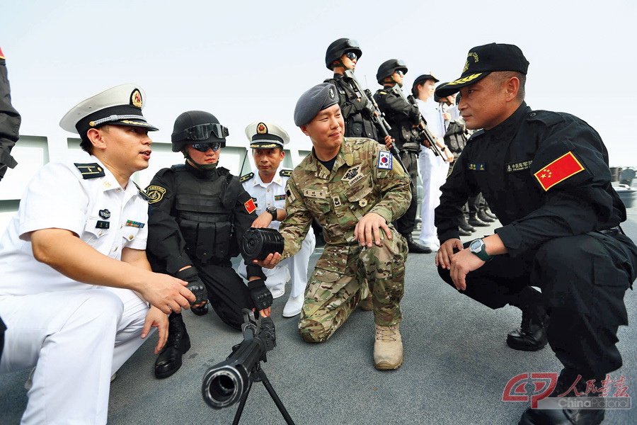 韩海军第二十九批护航编队特战队队长金大元在观摩中国海军第20批护航编队随舰特战装备展示，向特战队员了解准备性能  代宗锋摄  (7).jpg