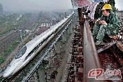 2010年10月13日，沪杭高铁的建设者观看飞驰而过的列车。“沪杭”客运专线（高铁）2010年10月26日正式开行，曾经奋战在这条158公里“战线”上的5万多建设者是高铁建设的坚强基石。 摄影 王芯克／青年时报