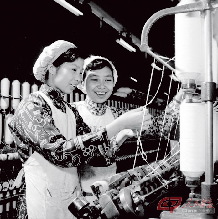 1956年，上海国棉十七厂的女工浦玉珍（左）与全国纺织模范黄宝妹交流经验。