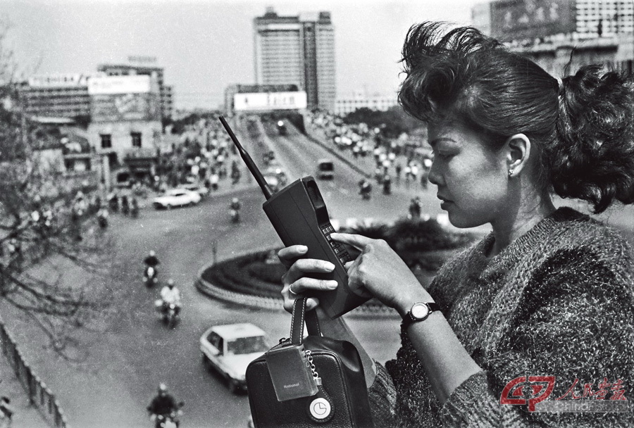 叶健强----大姐大“打”大哥 大 上个世纪八十年代，穿着时髦的靓女，当街捧个水壶般的“大哥大”。当时这把“壶”算是一种身份与财富的象征。叶健强1987年摄于广州江南.jpg