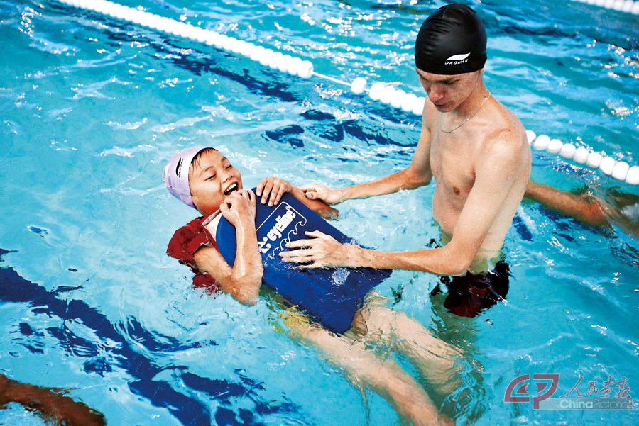 2008年7月21日，在俄罗斯符拉迪沃斯托克“海洋”全俄儿童中心，一名来自中国四川地震灾区的学生接受俄罗斯游泳教练指导。112984744_8.jpg
