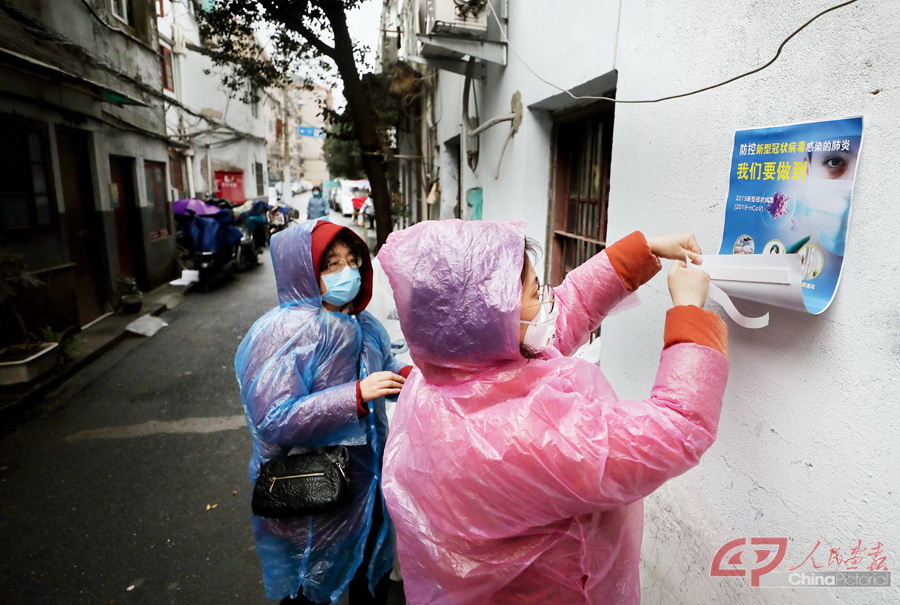 2020年1月27日，上海虹口区，祥德居民区工作人员在居民区道路旁张贴新型冠状病毒防控海报。拾城 周馨.jpg