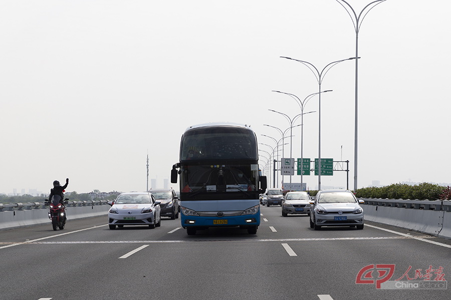 车队行驶途中，武汉市民在车队两侧护卫，表达敬意。.jpg